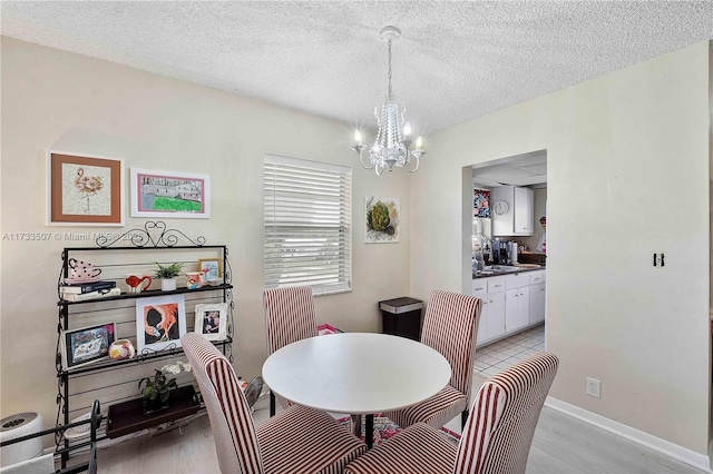 2751 E Golf Blvd Unit 2029, Pompano Beach, FL 33064 - dining room with a chandelier, light wood-type flooring, a textured ceiling, and baseboards