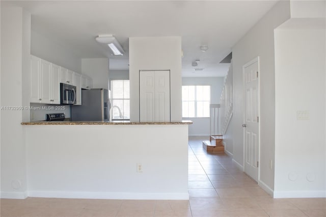 153 SE 28th Pl Unit 3, Homestead, FL 33033 - kitchen with appliances with stainless steel finishes, white cabinetry, a peninsula, and stone countertops