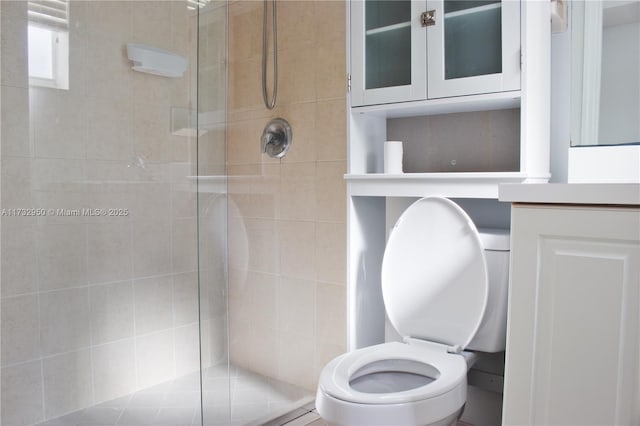 bathroom featuring toilet and a shower with door