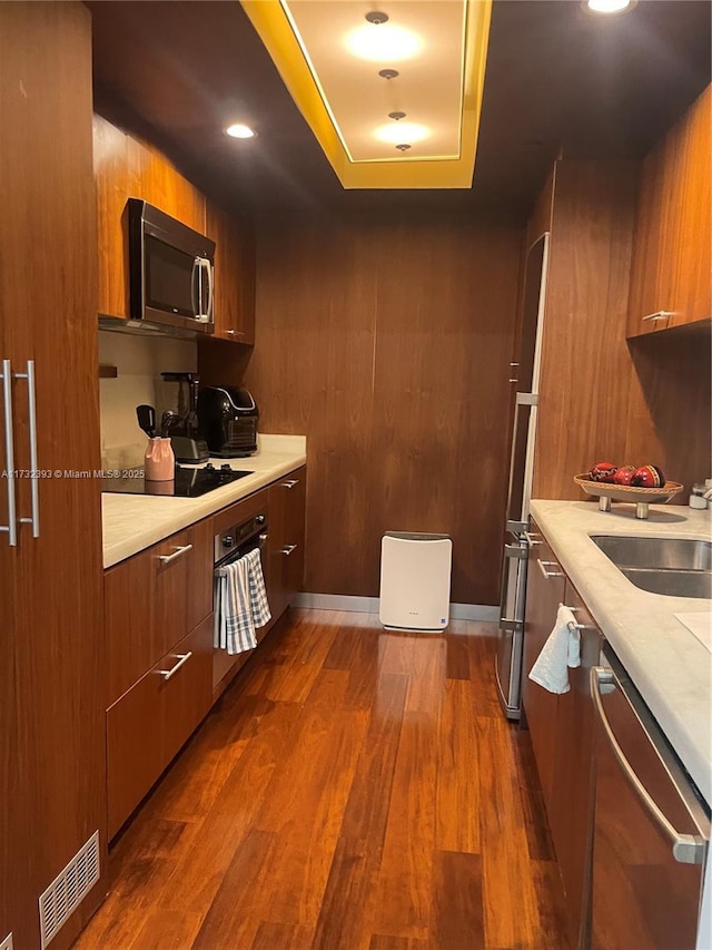 kitchen with visible vents, appliances with stainless steel finishes, dark wood-type flooring, a sink, and modern cabinets