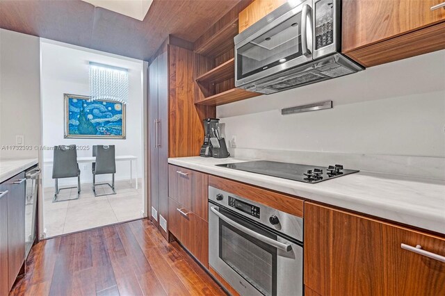50 Biscayne Blvd Unit 601, Miami, FL 33132 - kitchen featuring appliances with stainless steel finishes, brown cabinetry, modern cabinets, and light countertops