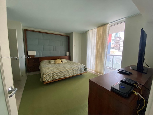 carpeted bedroom featuring a wall of windows