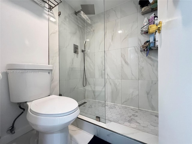 bathroom featuring a tile shower and toilet