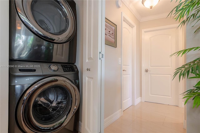 laundry room with crown molding, stacked washer and clothes dryer, and light tile patterned floors