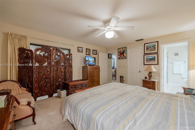 bedroom with ceiling fan, ensuite bath, and carpet flooring