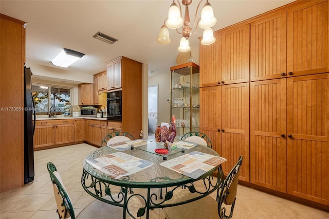 dining area featuring light tile patterned flooring, an inviting chandelier, and sink