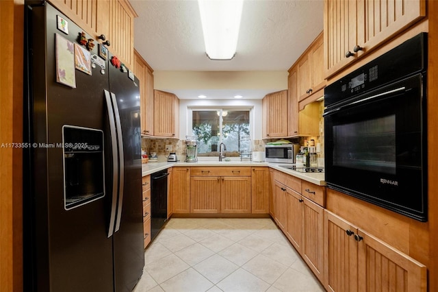 kitchen featuring sink, black appliances, a textured ceiling, light tile patterned flooring, and decorative backsplash