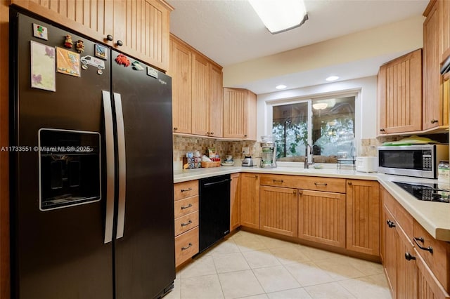 kitchen with backsplash, light tile patterned floors, and black appliances