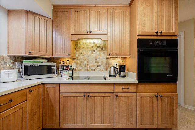 kitchen featuring tasteful backsplash and black appliances