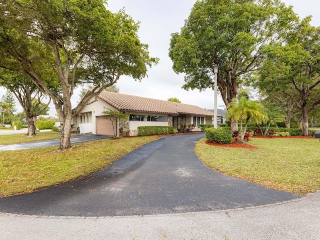 ranch-style house featuring a garage and a front yard