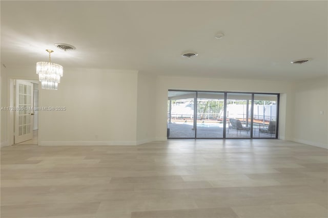 unfurnished room featuring ornamental molding and an inviting chandelier