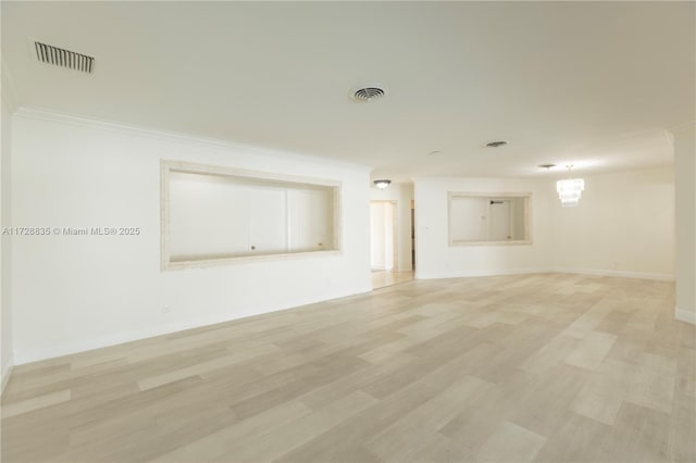 empty room featuring crown molding and light hardwood / wood-style floors