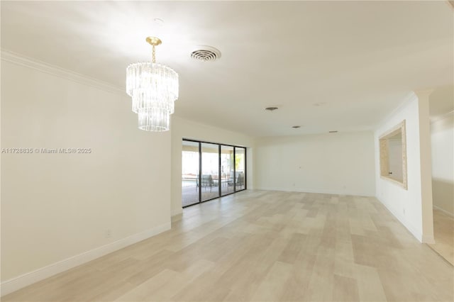 empty room featuring a notable chandelier, crown molding, and light wood-type flooring