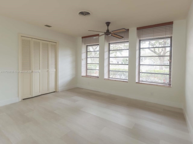 unfurnished bedroom with ceiling fan and a closet