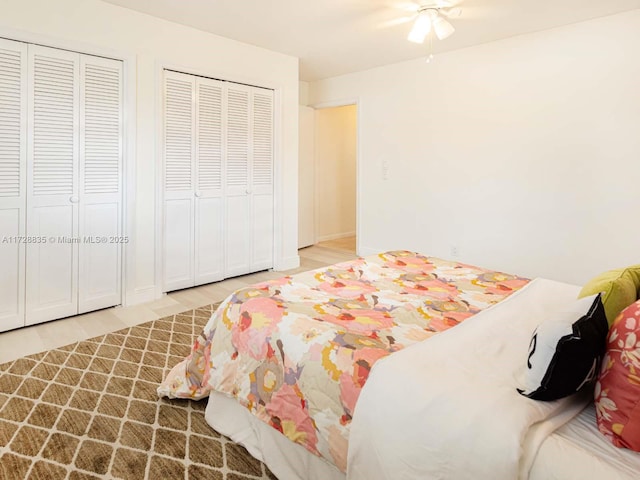 bedroom featuring multiple closets, ceiling fan, and hardwood / wood-style flooring