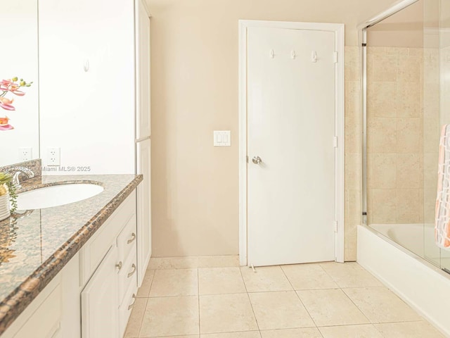 bathroom featuring vanity, tile patterned floors, and enclosed tub / shower combo