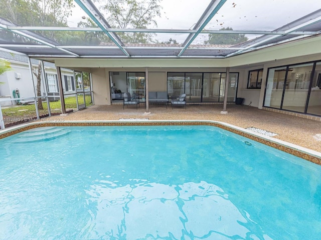 view of swimming pool with glass enclosure and a patio