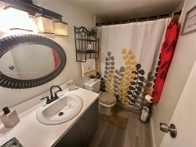 bathroom with walk in shower, wood-type flooring, toilet, and vanity