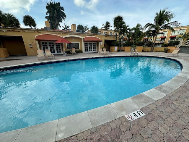 view of pool featuring a patio and french doors