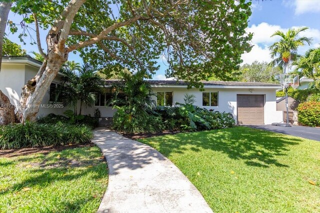 single story home featuring a garage and a front yard