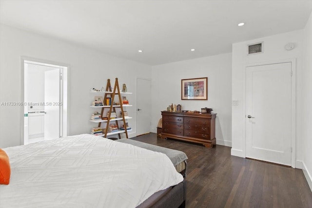 bedroom with ensuite bathroom and dark wood-type flooring