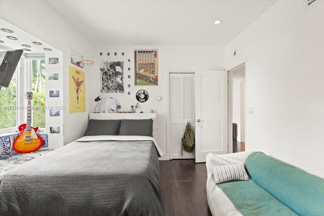 bedroom with dark wood-type flooring and a closet