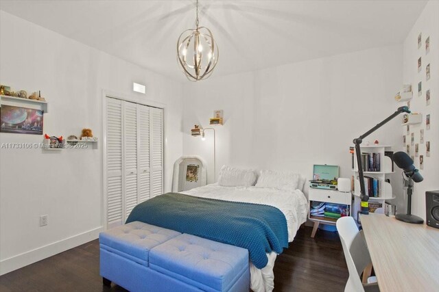 bedroom with dark hardwood / wood-style floors, a chandelier, and a closet