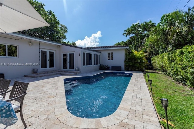 view of swimming pool with a patio area and french doors