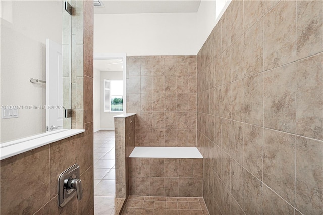 bathroom featuring tile patterned floors and a tile shower