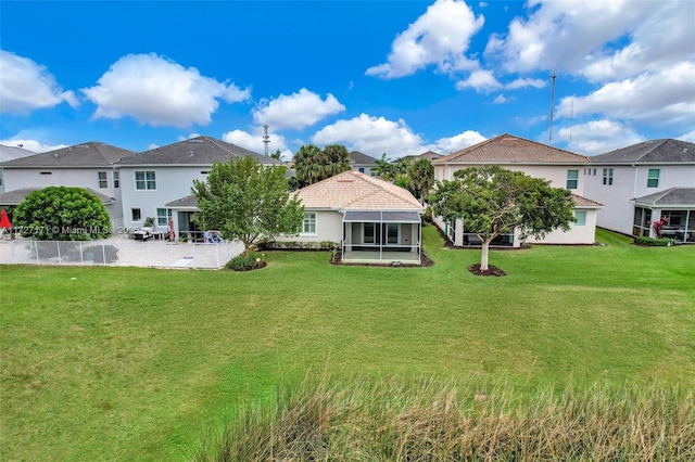 rear view of property featuring a gazebo, a sunroom, and a yard