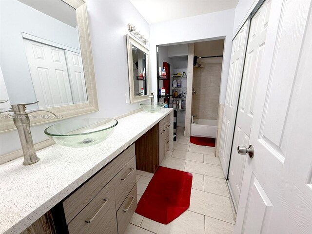 bathroom featuring vanity, tile patterned flooring, and tiled shower / bath combo