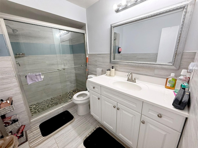 bathroom featuring tile walls, vanity, toilet, and walk in shower