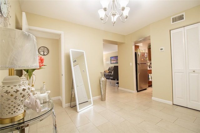 corridor with an inviting chandelier and light tile patterned flooring