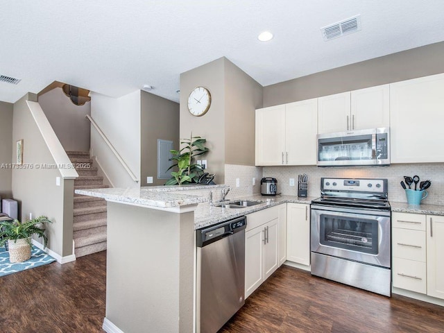 kitchen featuring appliances with stainless steel finishes, white cabinets, and kitchen peninsula