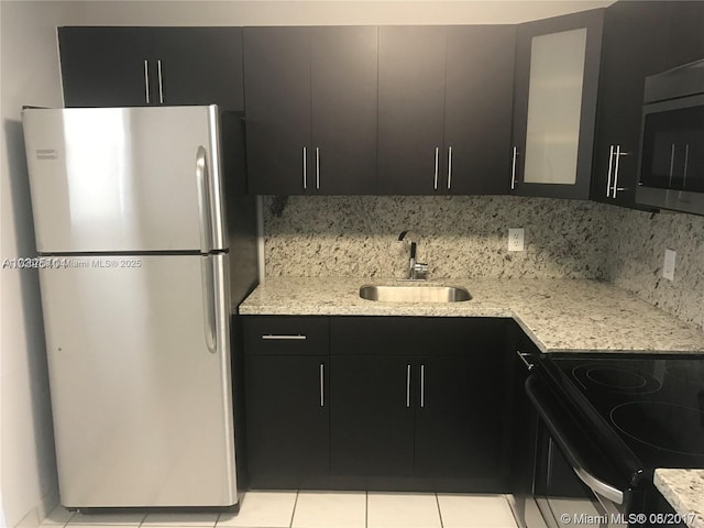 kitchen with tasteful backsplash, appliances with stainless steel finishes, sink, and light tile patterned floors