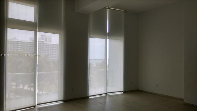 unfurnished room featuring tile patterned floors and a wealth of natural light