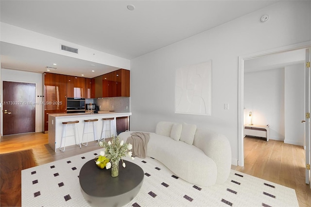 living room featuring a baseboard radiator and light hardwood / wood-style floors