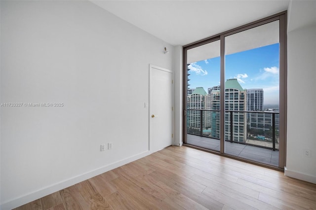 spare room featuring light hardwood / wood-style flooring and expansive windows