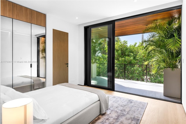 bedroom featuring access to outside, a closet, and light wood-type flooring