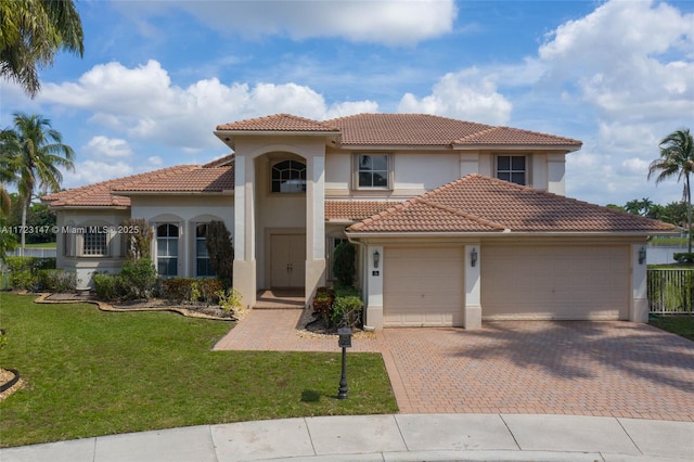 mediterranean / spanish-style home featuring a garage and a front yard