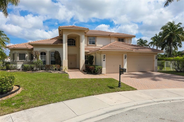 mediterranean / spanish home featuring a garage and a front yard