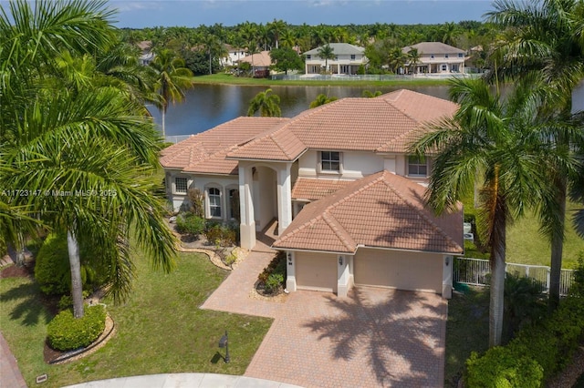 mediterranean / spanish-style home with a front yard and a water view