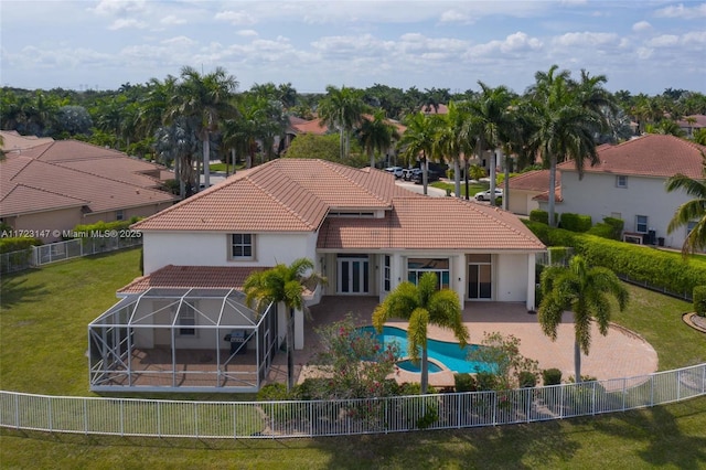 rear view of house with a fenced in pool, a patio, and a yard