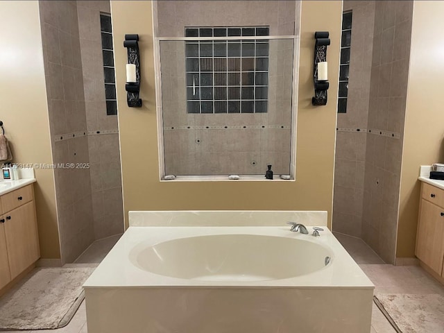 bathroom featuring vanity, a tub, and tile patterned floors