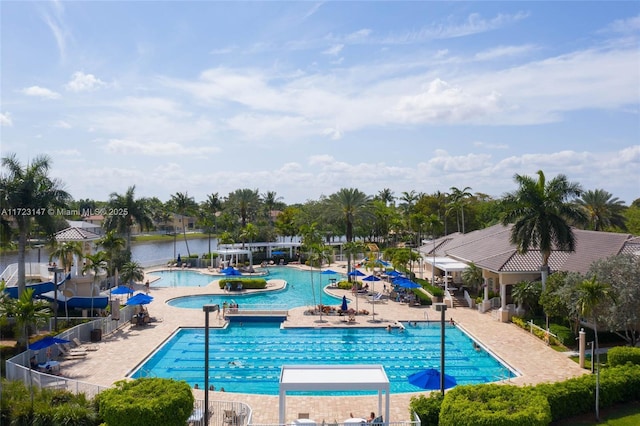 view of pool featuring a water view and a patio