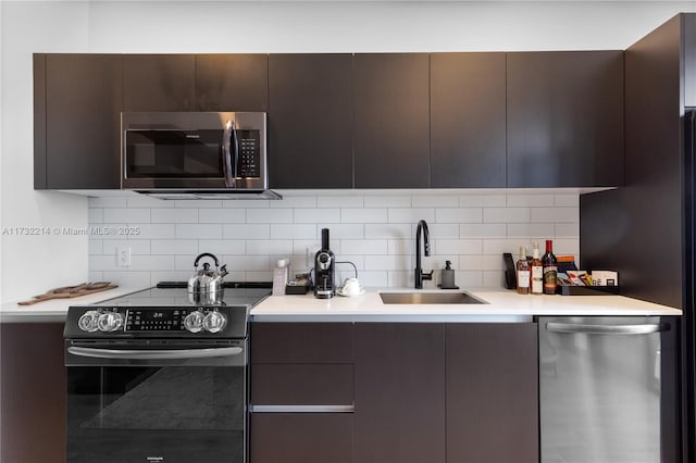 kitchen featuring stainless steel appliances, tasteful backsplash, sink, and dark brown cabinetry