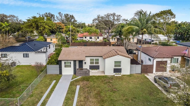 view of front of property with fence private yard, a residential view, and a tiled roof