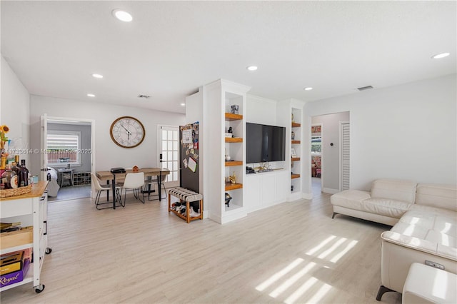 living room with light wood finished floors, visible vents, and recessed lighting