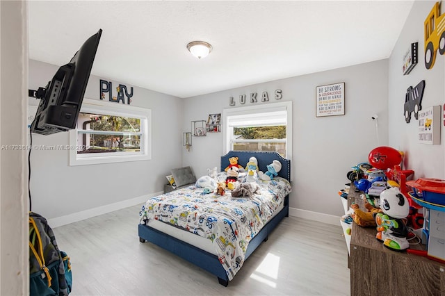 bedroom with baseboards and wood finished floors