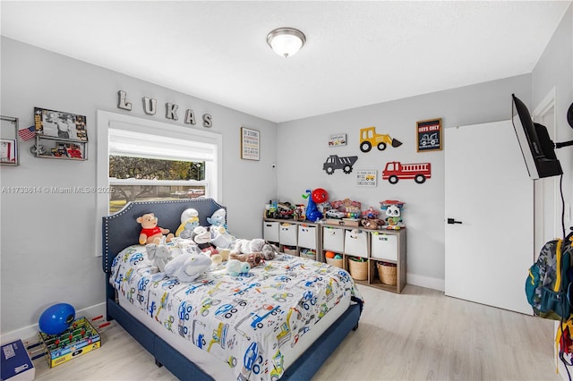 bedroom with wood finished floors and baseboards